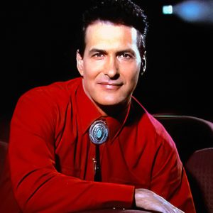 Joe Bob Briggs Monstervision, a man in a red shirt, sitting on a chair.