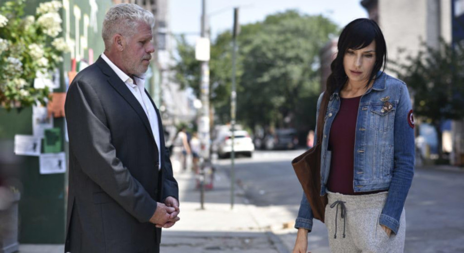 Asher (Ron Perlman) and Sophie (Famke Janssen) have a conversation out in the street that does not involve ways to kill her ailing mom in "Asher." (Photo courtesy IMDb.com)
