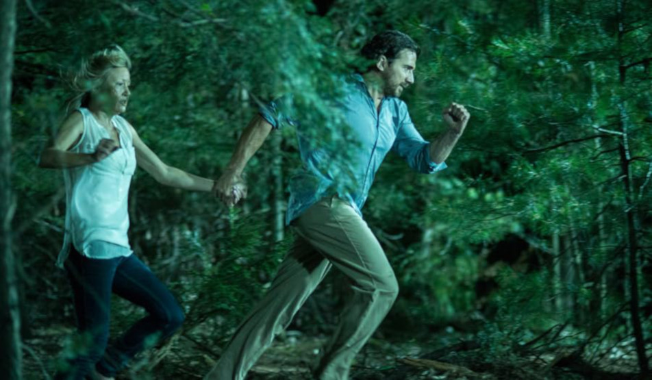 Ben Nagy reviews ‘Animal’: Genetically mutated wildebeest/wolf/bear/boar hybrid makes people hole up in a cabin in the woods 4 A man and woman running through the woods.