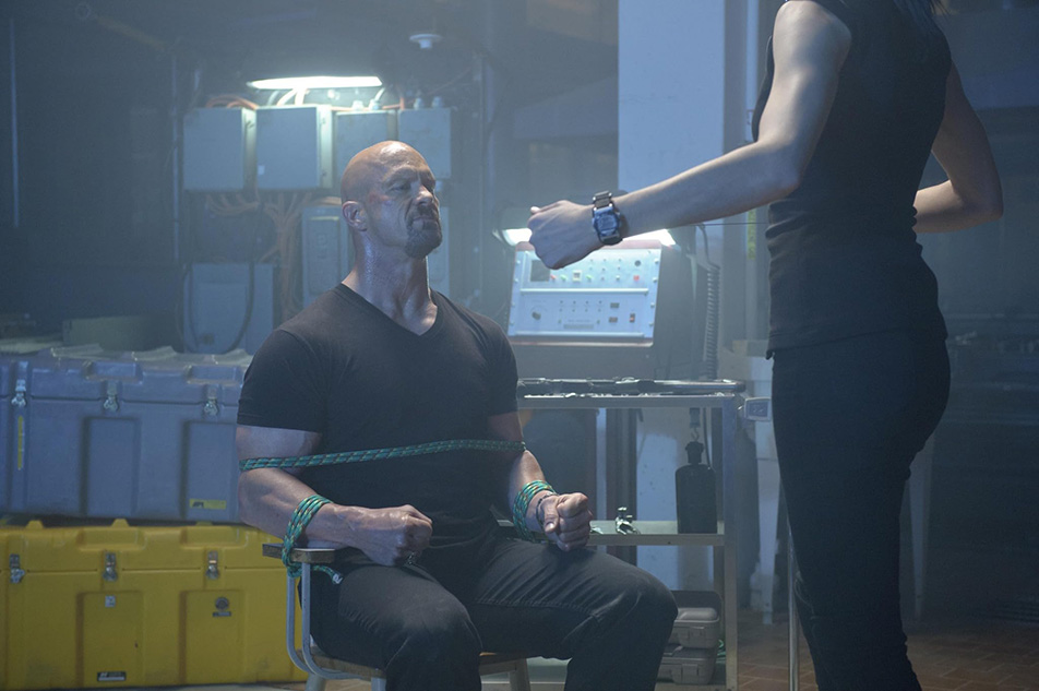‘The Package’: Stone Cold tries to deliver; Dolph pontificates on food 4 Torture expert Monique (Monique Ganderton) gets ready to work on Tommy Wick (“Stone Cold” Steve Austin in 2012’s “The Package.” (Photo courtesy IMDb.com)